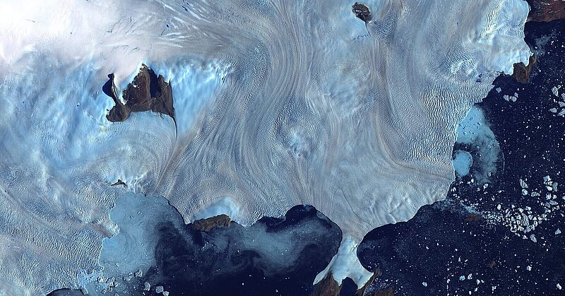 Along Greenland’s western coast, a small field of glaciers surrounds Baffin Bay. Aerial photo by the United States Geological Survey.