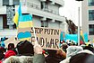Protesters in Germany gather in support of Ukraine and hold up the colours of the Ukrainian flag. A sign reads "STOP PUTIN END WAR".