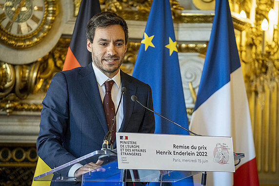 Tarik Abou-Chadi accepts the Henrik Enderlein Prize at a lectern at the French Foreign Ministry in Paris.