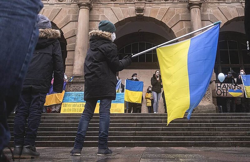 A young boy waving a ukrainian flag in the center of a demonstration showing solidarity with Ukraine in Bielefeld, Germany.