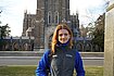 Charlotte standing in front of a gothic architectural building in a Duke vest.